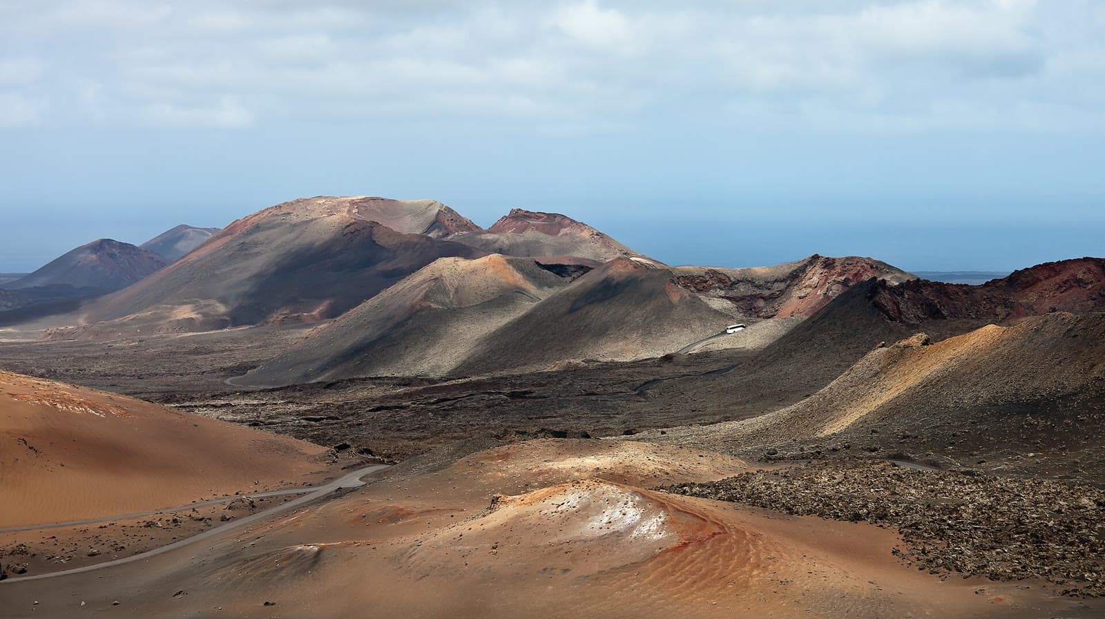 Paisaje volcánico de Timanfaya con conos oscuros y rojizos en Lanzarote
